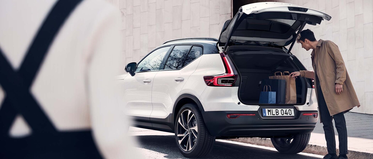 Bilde av en mann som henter ut noe av bagasjerommet på en Volvo XC40 Bilde av en mann som henter ut noe av bagasjerommet på en Volvo XC40