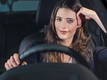 Bilde av fornøyd kvinne bak rattet