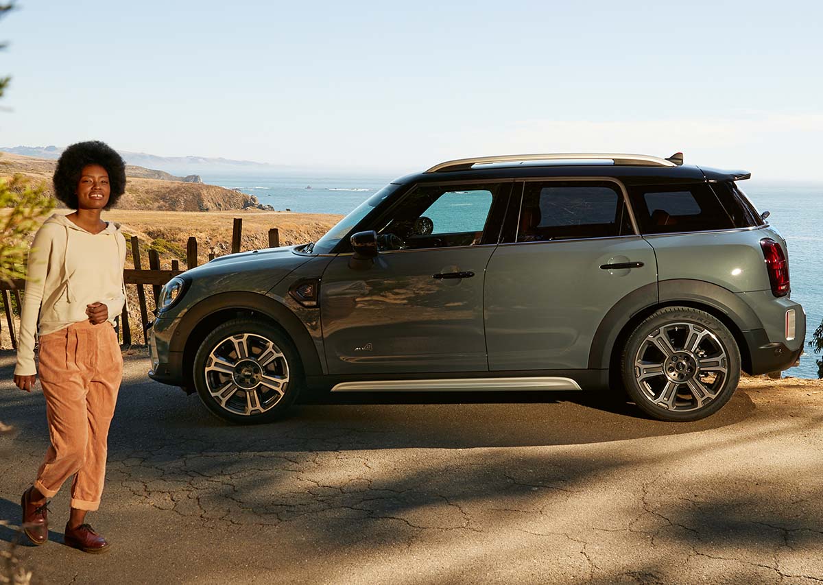 Bilde av en kvinne og en MINI Countryman ved sjøen Bilde av en kvinne og en MINI Countryman ved sjøen