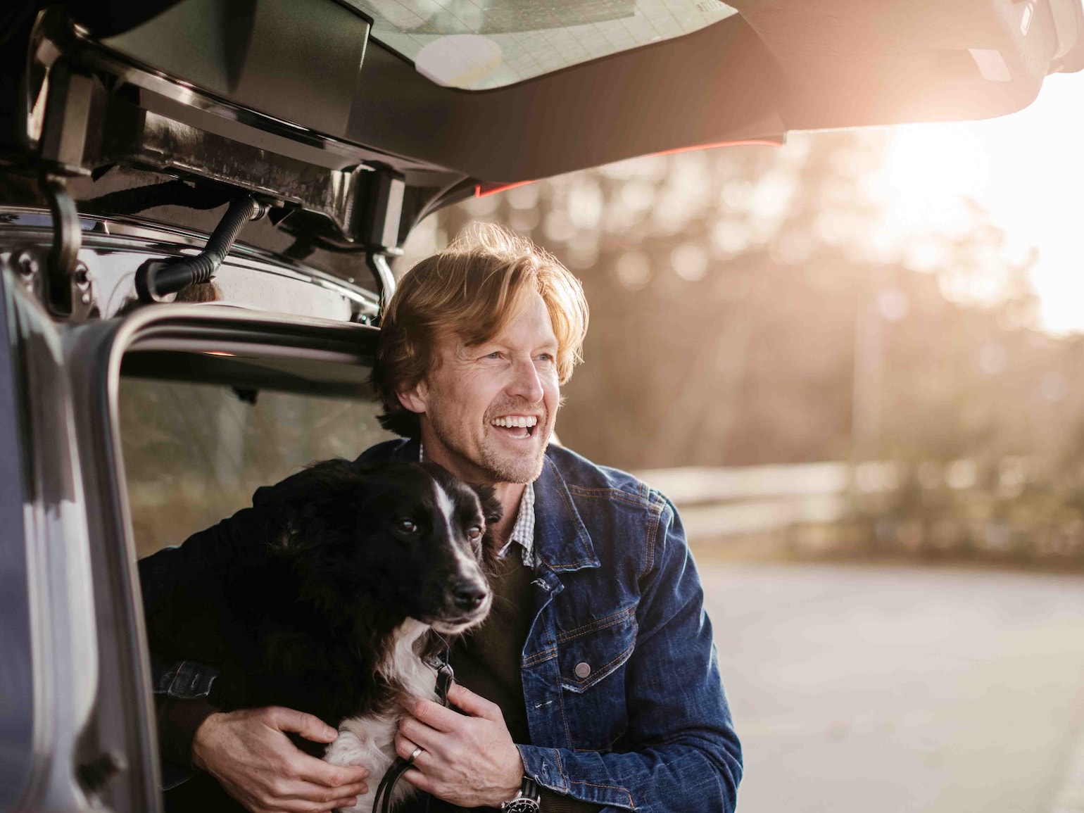 Mannen koser med hunden sin i bilen